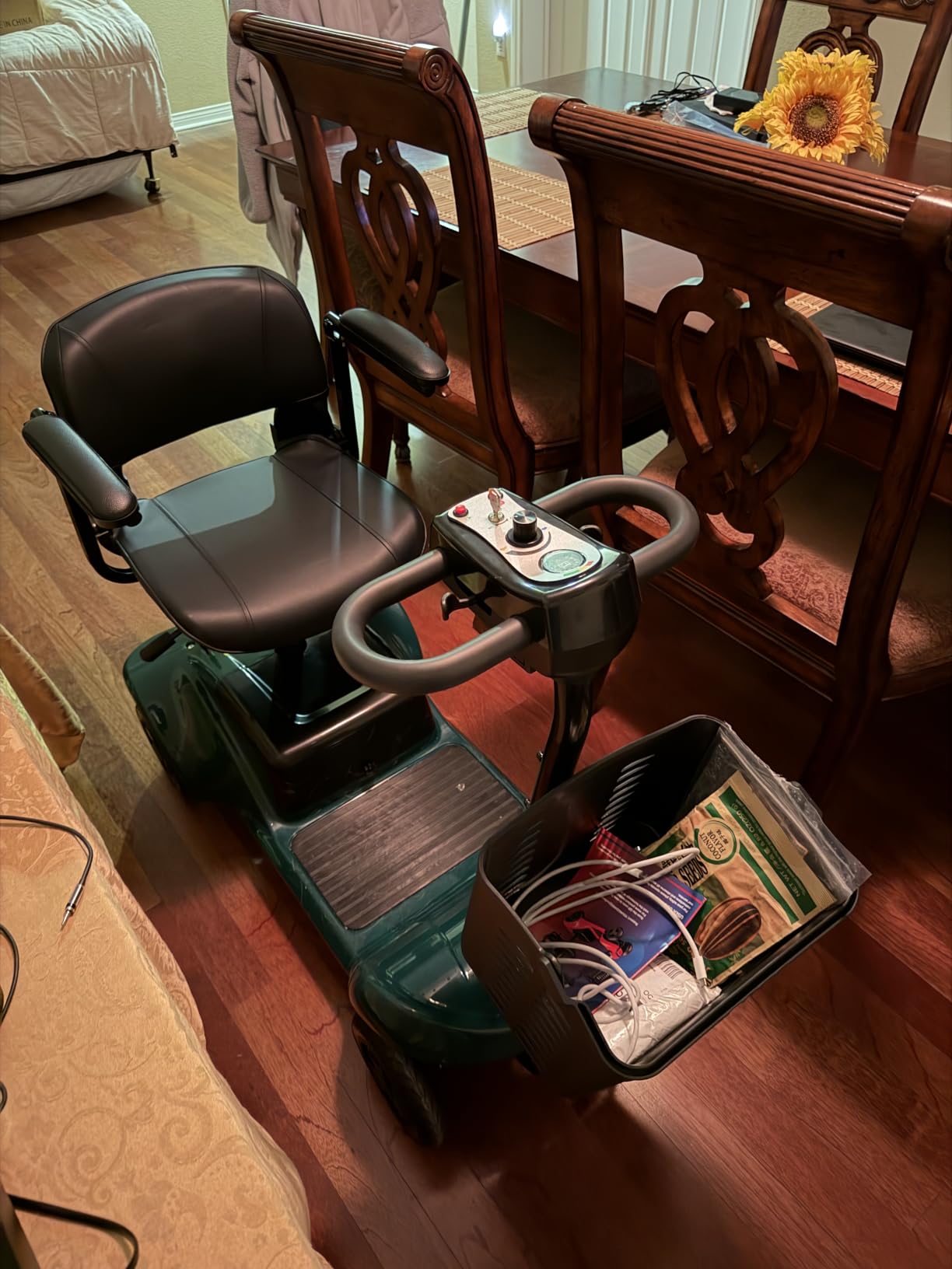 Mobility scooter with swivel seat and loaded basket parked in a dining room